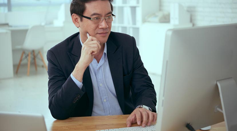 Man-in-glasses-and-suit-looking-at-a-computer