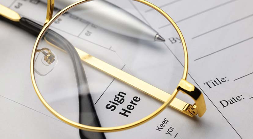 gold-framed-glasses-on-top-of-papersgold-framed-glasses-on-top-of-papers