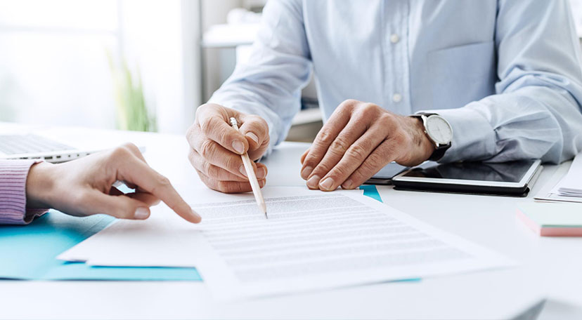 A lender going through payroll business loan contract terms with borrower